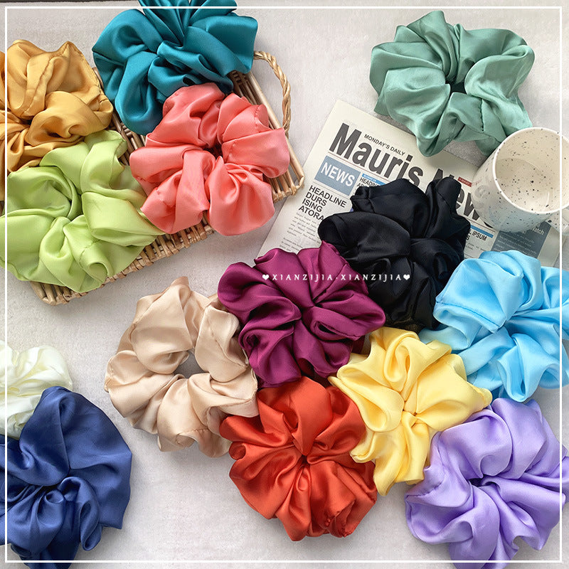 Oversized Satin Headband for Women in various colors, displayed with a basket and a magazine on a flat surface.